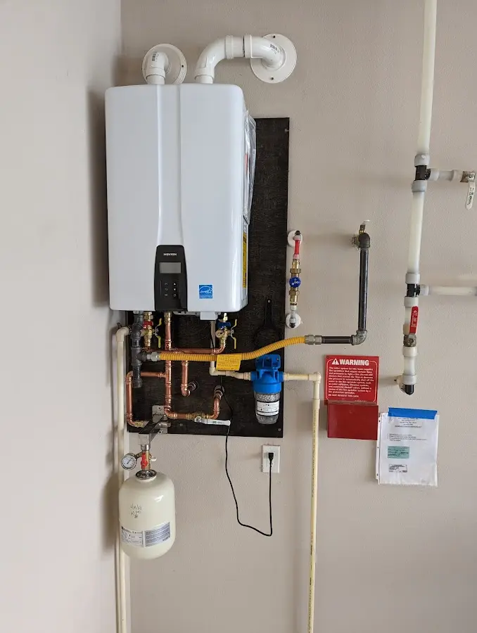 Professional plumber installing copper piping in a Granby home